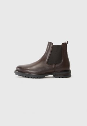 Stivale Chelsea in pelle marrone con pannelli laterali elastici neri, punta rotonda e suola in gomma texturizzata. Dotato di linguetta per una facile vestibilità.
