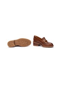 Mocasines de cuero marrón con punta redonda, una hebilla decorativa en tono dorado y una suela de goma texturizada en color beige con patrones de tracción.