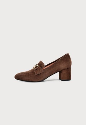 Mocassin en daim marron avec une boucle dorée et un talon bloc épais, présenté de profil sur un fond uni.