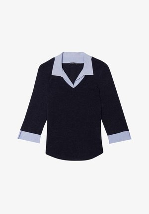 Top blu navy con scollatura a V, con colletto e polsini a righe azzurre chiare. Il materiale sembra testurizzato; le maniche sono a tre quarti.