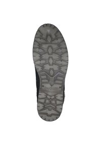 Svart skosula med ett robust mönster av geometriska former och en upphöjd logotyp. Materialet verkar hållbart med en strukturerad yta.