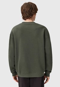 Felpa verde scuro con scollatura a girocollo, spalle scese e polsini a coste. Texture liscia e design minimalista senza fantasie.