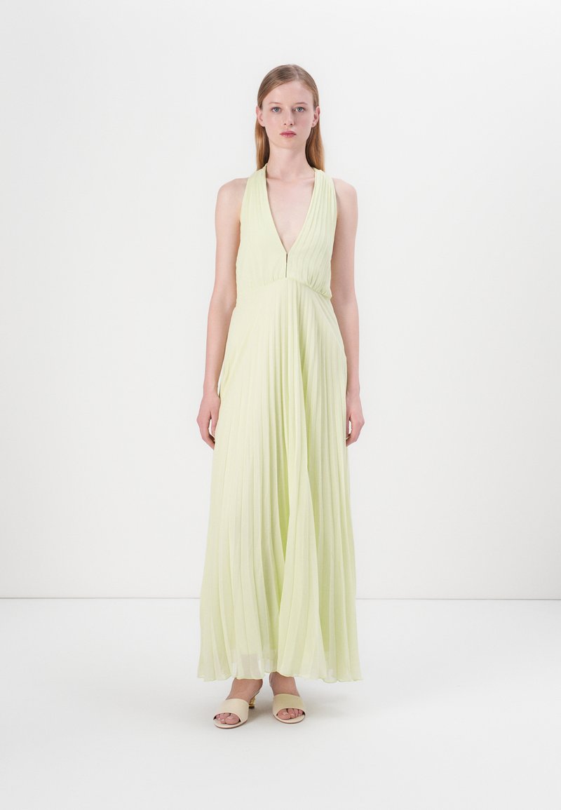Abito maxi a pieghe verde chiaro con scollatura a V profonda e gonna fluente. Tessuto morbido, design senza maniche e leggero luccichio.