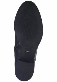 Semelle de chaussure noire avec surface en caoutchouc texturé, présentant un léger soutien de la voûte plantaire, avec le nom de la marque en relief et le marquage de taille 37. Fabriqué en Italie.