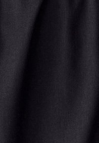 Black fabric with a fine texture, appearing smooth and slightly reflective, draped with subtle creases.