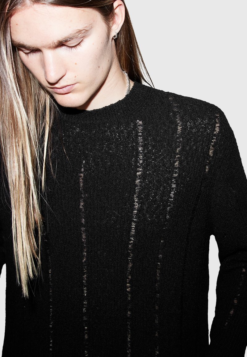 Schwarzer Strickpullover mit strukturiertem Muster, der vertikale Streifen unterschiedlicher Dicke und einen Rundhalsausschnitt aufweist.