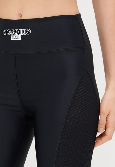 Črne legice z gladko teksturo, ki imajo visok pas in mrežasto ploščo na strani. Logotip je natisnjen spredaj.