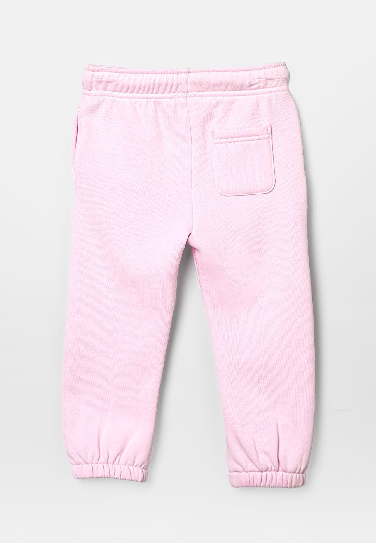 Pantalon de survêtement rose clair en tissu doux, avec une taille élastique et une poche arrière, et des poignets ajustés aux chevilles.
