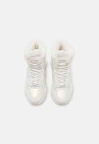 White high-top sneakers with faux fur trim, glossy panels, and textured laces. Features a padded collar and embroidered logo on the tongue.