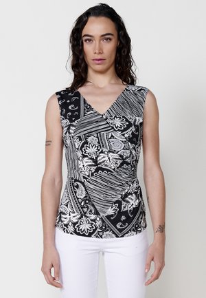 Black and white sleeveless top with a V-neck, featuring a mix of paisley and floral patterns with angular lines and draped texture.