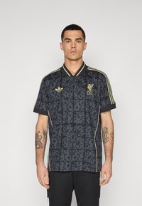 Fekete és arany Liverpool futballmez mintás dizájnnal, rövid ujjakkal, gallérral és három arany csíkos díszítéssel.