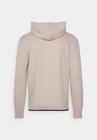 Felpa beige con design semplice, caratterizzata da un grande cappuccio, maniche lunghe e polsini a coste. Texture liscia con un accento nero all'orlo.