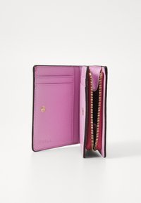 Portefeuille Furla en cuir rose avec des accents marron, présentant plusieurs emplacements pour cartes, un compartiment zippé et des détails en matériel doré.
