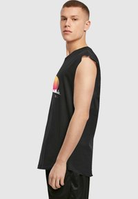 Tricou negru fără mâneci, cu guler rotund, având un grafic colorat al apusului și un design cu siluete ale orașului pe piept. Material din bumbac.