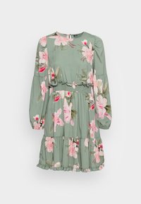 Robe fleurie à base verte, motifs floraux roses, manches longues bouffantes, ourlet à volants et taille élastique pour une coupe décontractée.