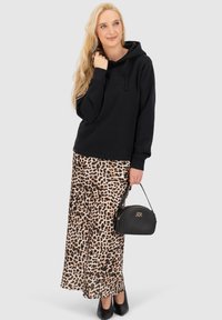 Felpa nera con cappuccio, gonna maxi in stampa leopardata, scarpe nere con tacco e una piccola borsa nera con accessori dorati. Tessuto liscio e design casual.