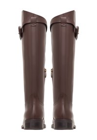 Brown leather knee-high boots with a textured finish, side buckle accents, and a flat heel, showcasing a fitted and smooth design.