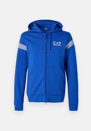 Blue zip-up hoodie with a hood, featuring a white EA7 logo, two front pockets, and striped accents on the sleeves. Soft fabric texture.