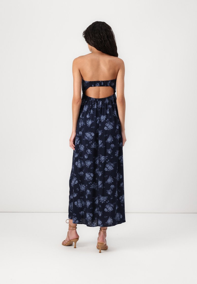 Marineblaues Blumenmaxikleid mit trägerlosem Design und offenem Rücken. Verfügt über eine fließende Silhouette und strukturierten Stoff mit blauen Blumenmustern.