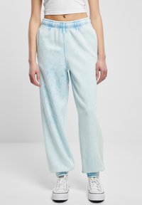 Svijetloplave trenirke od mekog materijala, s uzorkom tie-dye, elastičnom strukom i uskim manžetama na gležnjevima.