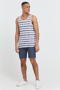 Top fără mâneci, cu dungi alb, albastru și vișiniu, având bretele late. Asortat cu pantaloni scurți din denim și adidași albi.