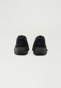 Pantofi sport negri, realizati dintr-o combinație de material mesh și suede, cu o formă rotundă, guler căptușit și tălpi din cauciuc texturat.