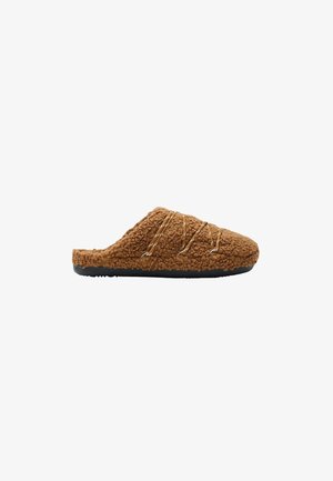 Chausson marron en tissu duveteux à enfiler avec semelle noire et lacets croisés décoratifs sur le dessus, conçu pour le confort intérieur.
