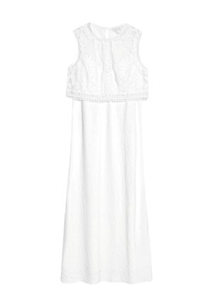 Vestido blanco sin mangas con una tela texturada, bordado floral en el cuerpo y una falda larga y fluida con un dobladillo en forma de concha.