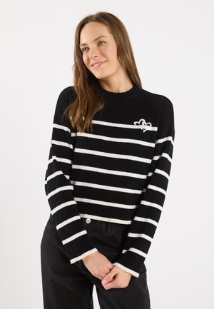 Black and white striped sweater with a ribbed texture and crew neckline. Features a small embroidered design on the chest.