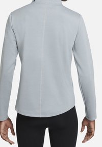Maglia grigia chiaro a maniche lunghe con colletto alto, caratterizzata da un design senza cuciture e da cuciture sottili lungo la schiena. Tessuto liscio e aderente.
