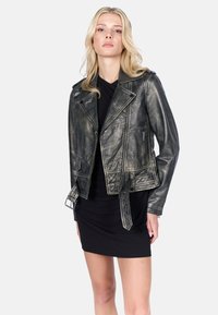 Zwarte leren motorjack met metallic afwerking, diagonale rits, schouderepauletten en drukknoopzakken. Strak aansluitend ontwerp.