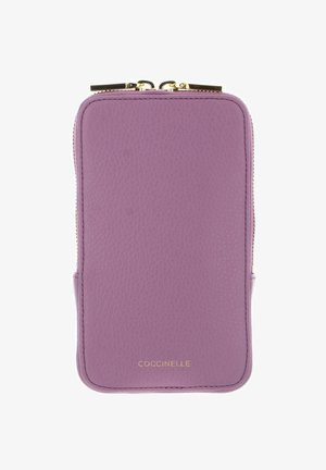 Portefeuille en cuir violet avec fermeture éclair double ton or et nom de la marque "COCCINELLE" embossé en or au centre en bas.