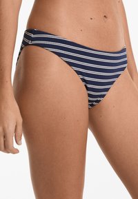 Navy in bele beli kopalke z nizkim pasom, z gladko teksturo in minimalnimi šivi.