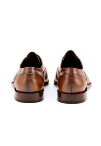 Chaussures en cuir marron avec une finition lisse, des talons arrondis et des détails de couture visibles ; conçues avec une silhouette classique.