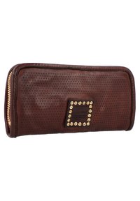 Portafoglio in pelle marrone con texture perforata, zip dorata e una placca metallica decorativa con borchie incorporate. Forma rettangolare.