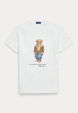 White cotton T-shirt featuring a graphic of a dressed cartoon bear. Notable details include a brown jacket, yellow hoodie, and blue jeans.