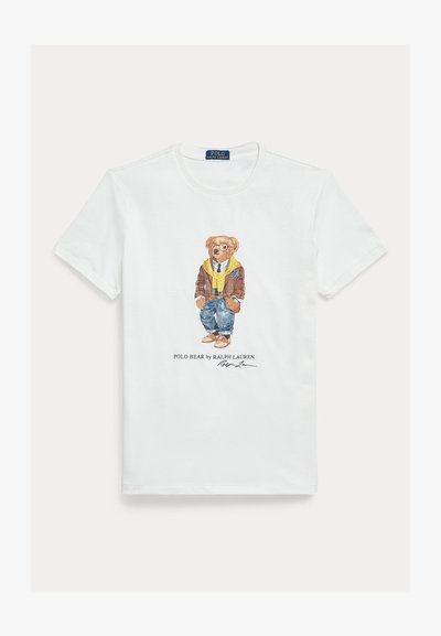 Tricou alb din bumbac cu un desen grafic al unui urs de desene animate îmbrăcat. Detalii notabile includ o jachetă maro, un hanorac galben și blugi albaștri.