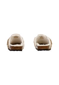Zapatos de ante marrón de tipo slip-on con forro de piel sintética blanca y suela de goma texturizada, que presentan una pequeña hebilla decorativa a cada lado.