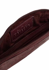 Bordo audinio maišelis su užtrauktuku ir odiniu žymekliu viduje, su dekoratyviais siuvinėjimais ir lygiu vidiniu paviršiumi.