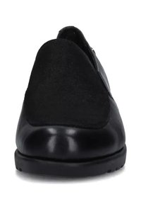 Scarpa nera slip-on con corpo in pelle liscia, pannello superiore in camoscio, punta arrotondata e suola bassa in gomma. Dettagli hardware minimi.