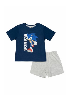 Marineblaue kurzärmlige Hemd mit dem rennenden Sonic-Charakter und dem Text "SONIC", kombiniert mit hellgrauen Shorts mit elastischem Bund.
