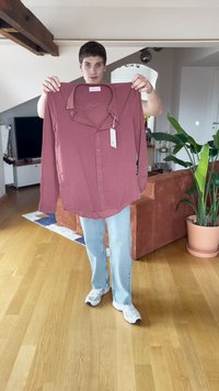 Pitkähihainen, nappilistalla varustettu paita pölyruusun värissä, kevyt kangas pehmeällä tekstuurilla. Ominaisuuksiin kuuluu klassinen kaulus ja kiinnitetty etiketti.