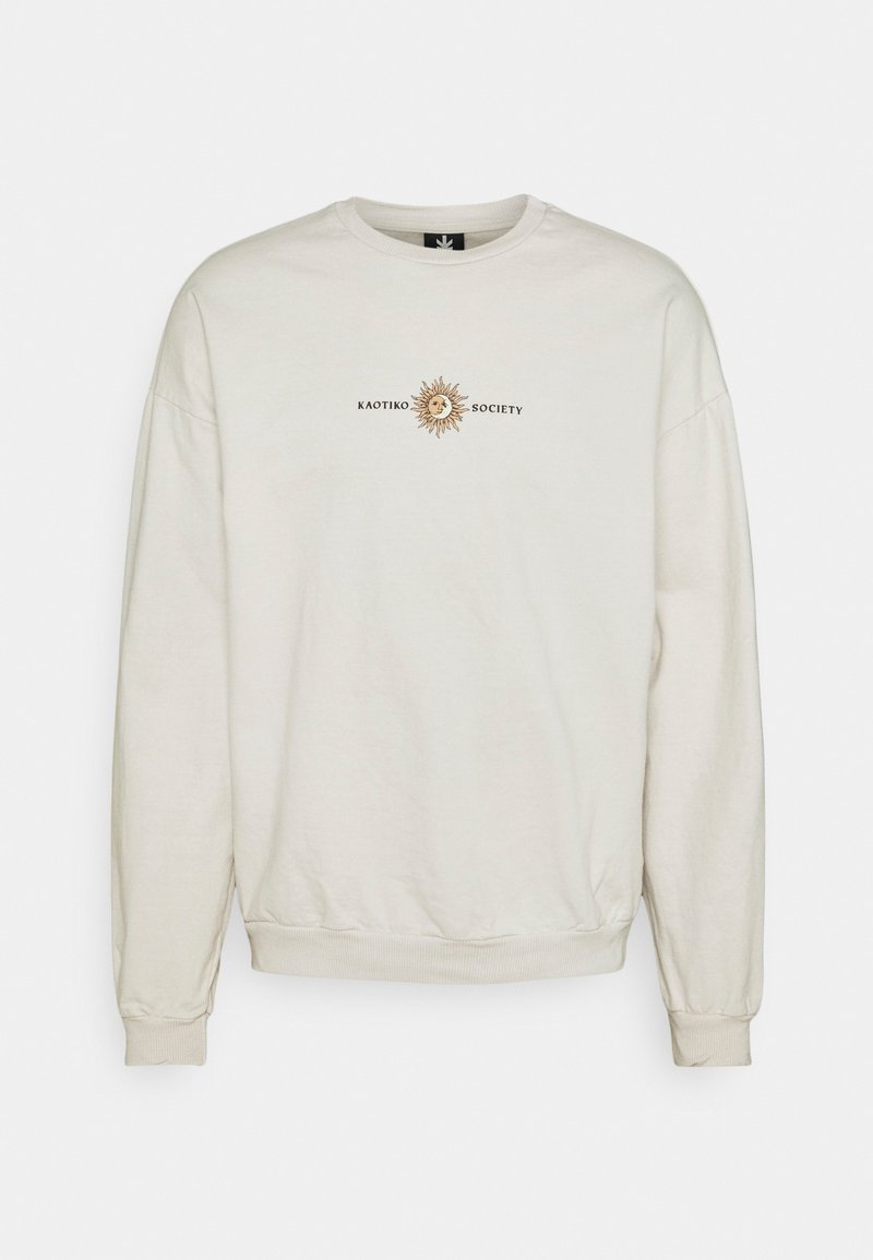 Felpa beige chiaro con scollo rotondo, polsini e orlo a costine, con una grafica di un sole stampata e il testo "KAOTIKO SOCIETY."
