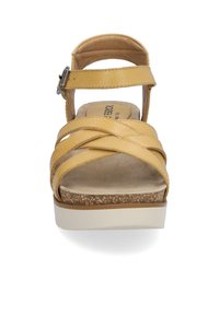 Żółte skórzane sandały z krzyżującymi się paskami, regulowanym zapięciem, wyściółką na podeszew i podeszwą przypominającą korek. Prosty i łatwy w użyciu design.