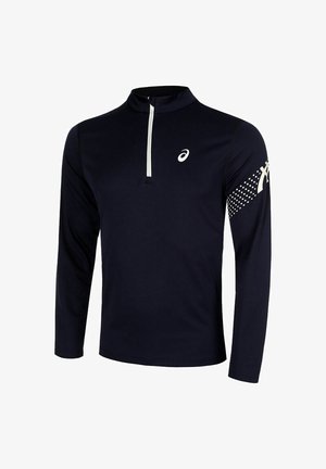 Camiseta atlética de manga larga color navy con media cremallera, que presenta un logo blanco en el pecho y un patrón de puntos en la manga derecha. Textura de tela suave.