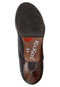 Svart lädersula med texturerad gummiyttersula, röd accent och vit "Kickers 37" märkning på insidan av hälen.