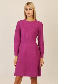 Fuchsienfarbenes Strickkleid mit Zopfmuster am Oberteil, langen Ärmeln und einem ausgestellt geschnittenen Rock. Verfügt über eine gerippte Textur und einen Rundhalsausschnitt.