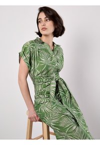Grünes Kleid mit Blattdruck, kurzen Ärmeln, Kragen und Knopfverschluss. Verfügt über eine gebundene Taille und einen strukturierten Stoff mit lockerer Passform.