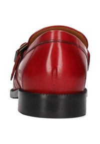 Scarpa in pelle rossa con finitura liscia, retro arrotondato e suola nera. Presenta una fibbia laterale per la chiusura. Dettagli di cucitura minimi visibili.