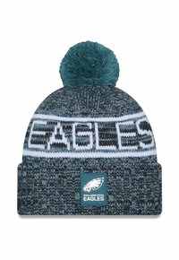 Knit beanie in teal and gray with a white band reading "EAGLES." Features a pom-pom on top and a logo patch at the front.